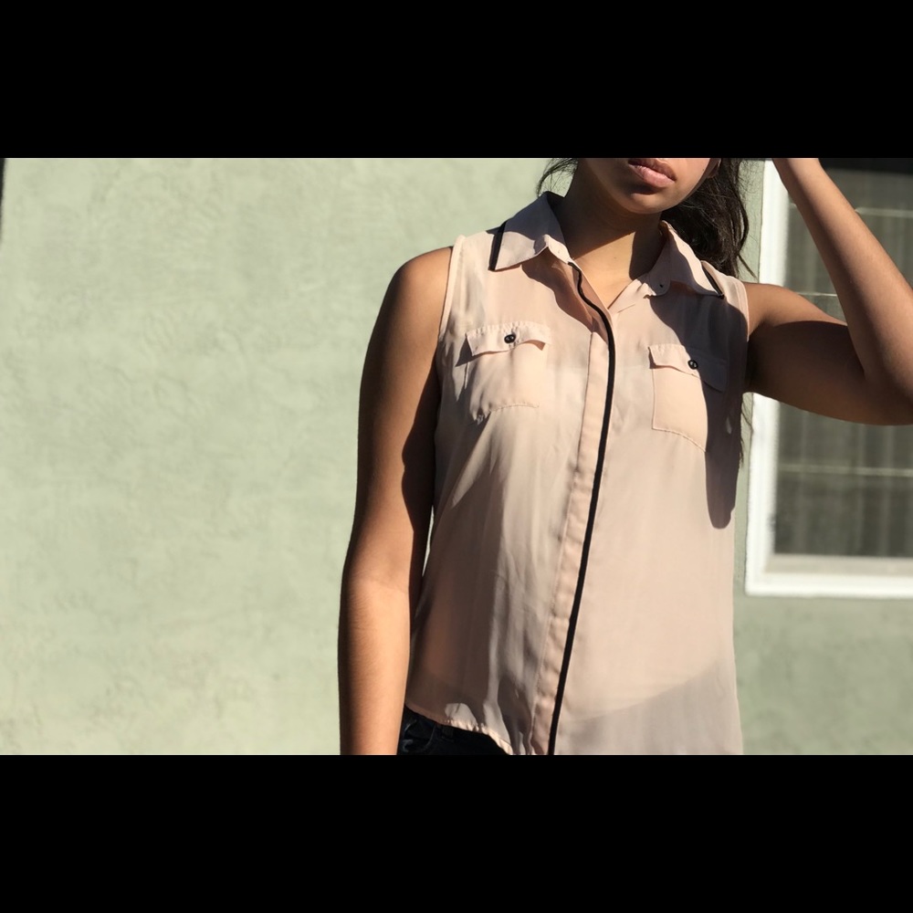 Tan, sleeveless, collared blouse.